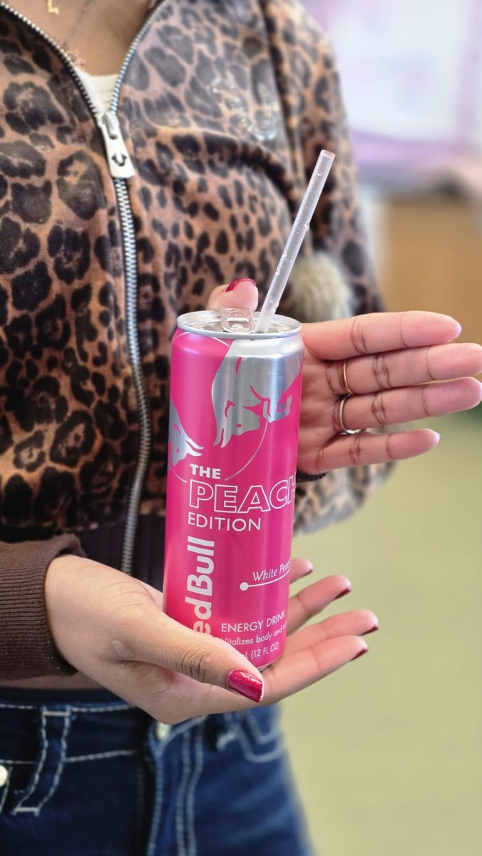Senior Shalimar Cazales holding a Red Bull Peach Edition Energy Drink.